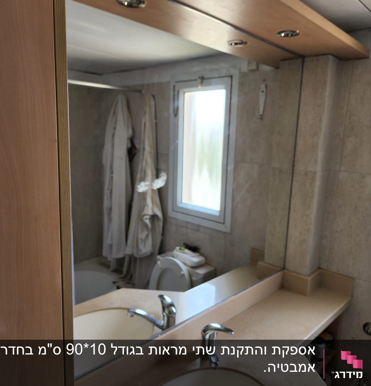 מראה גדולה מעל כיור בחדר אמבטיה